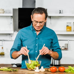 Protects the Liver – Man tossing a salad in the kitchen